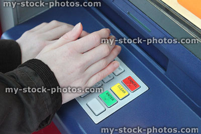 Stock image of hiding PIN numbers at cashpoint / cash machine (ATM)