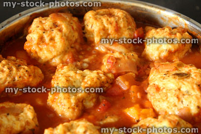 Stock image of homemade chicken casserole in saucepan, with dumplings floating