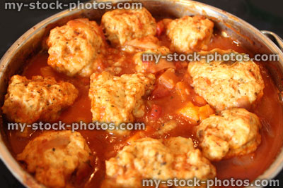 Stock image of homemade chicken casserole in saucepan, with dumplings floating