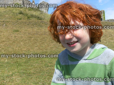 Stock image of young red head boy on castle hill with messy hair