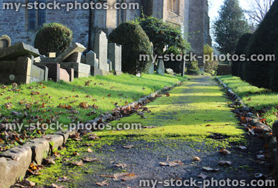 Stock image of neglected RIP gravestones / crosses, church graveyard cemetery, leaning / falling over