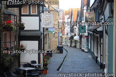 Stock image of medieval shops / houses, flagstone shopping street / Cheap Street, Frome, Somerset England, stream, rill