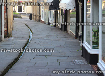 Stock image of medieval shops / houses, flagstone shopping street / Cheap Street, Frome, Somerset England, stream, rill