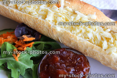 Stock image of cheese sandwich / baguette, salad, picket, grated Cheddar cheese