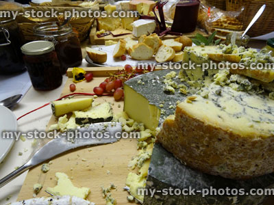 Stock image of stack of cheeses / Stilton, Cornish Yarg cheese cake on wooden board