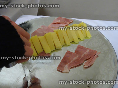 Stock image of Cheddar cheese triangles and ham slices, breakfast platter