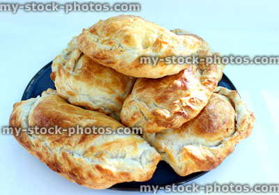 Stock image of freshy baked Cornish pasties / pasty on blue plate