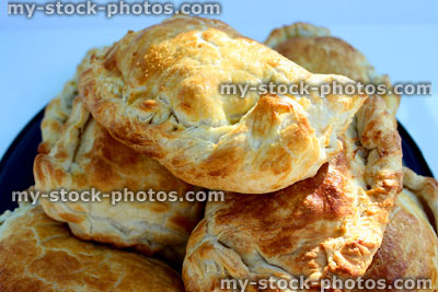 Stock image of freshy baked Cornish pasties / pasty on blue plate