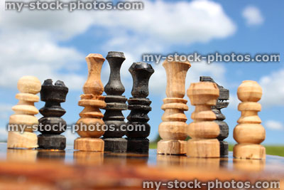 Stock image of chessboard game / wooden chess pieces against sky, boardgame