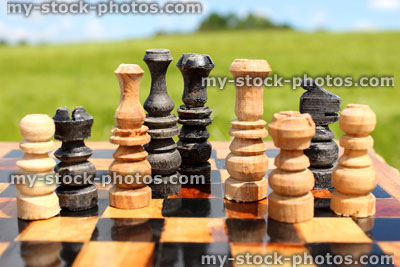 Stock image of chessboard game / wooden chess pieces against sky, boardgame