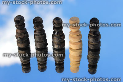 Stock image of wooden chess pieces (pawns) reflected against sky, odd one out