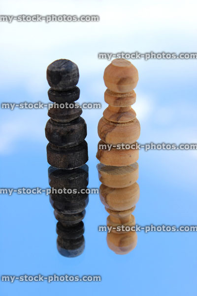 Stock image of chess pieces reflected against sky (single black and white pawns)