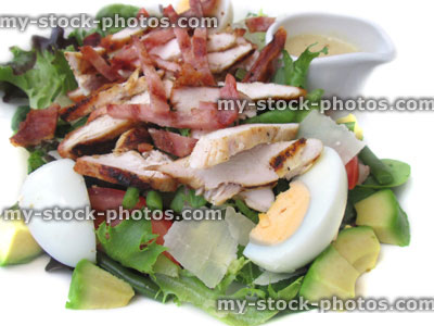 Stock image of grilled chicken and bacon salad, boiled egg, avocado, tomato, green beans, Parmesan cheese