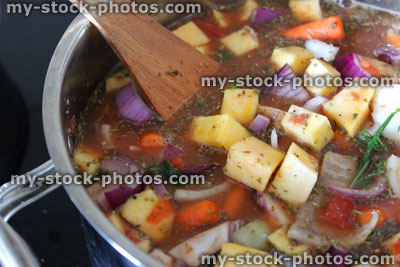 Stock image of chicken stew / vegetable casserole cooking in saucepan / pan, vegetable soup