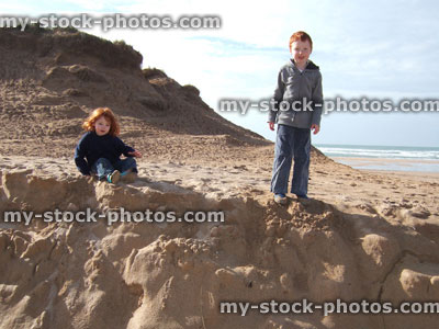 Stock image of young boy and girl standing on beach, Cornwall