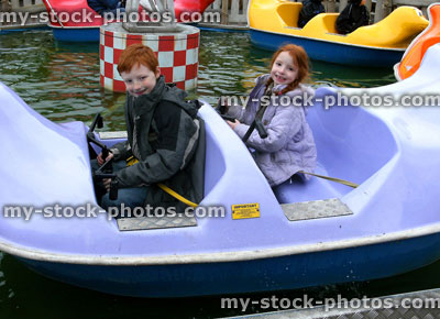 Stock image of young children on amusement boat ride, boating lake