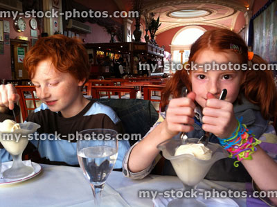 Stock image of two children eating ice cream in an Indian Restaurant