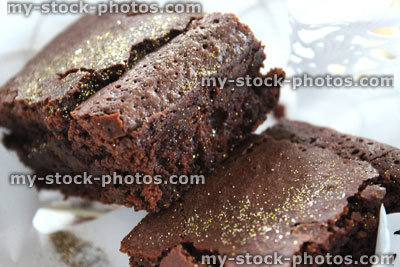 Stock image of homemade chocolate brownies with golden edible glitter, paper doily