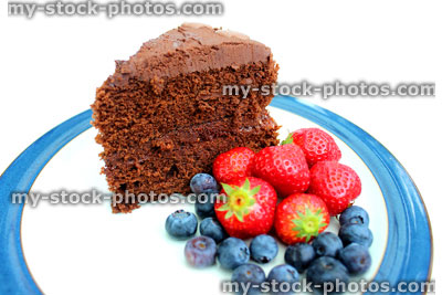 Stock image of rich homemade chocolate cake, with strawberries and blueberries