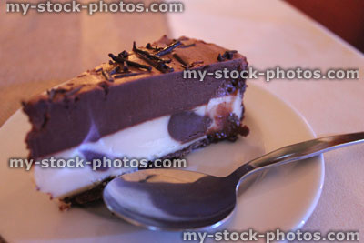 Stock image of homemade vanilla and chocolate cheesecake, cake slice, biscuit base, spoon