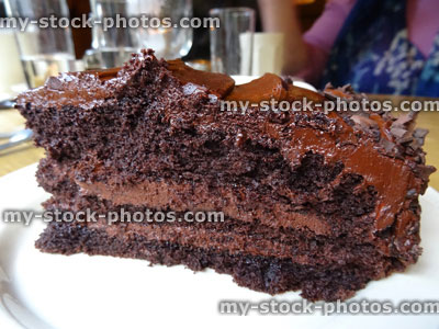 Stock image of homemade chocolate fudge cake slice, cream, ganache butter icing