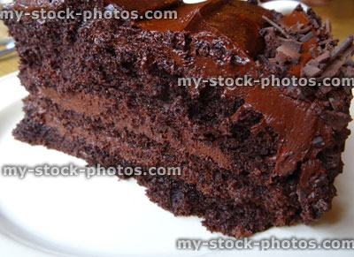 Stock image of homemade chocolate fudge cake slice, cream, ganache butter icing