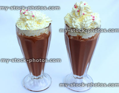 Stock image of chocolate milkshakes topped with whipped cream, American diner glasses