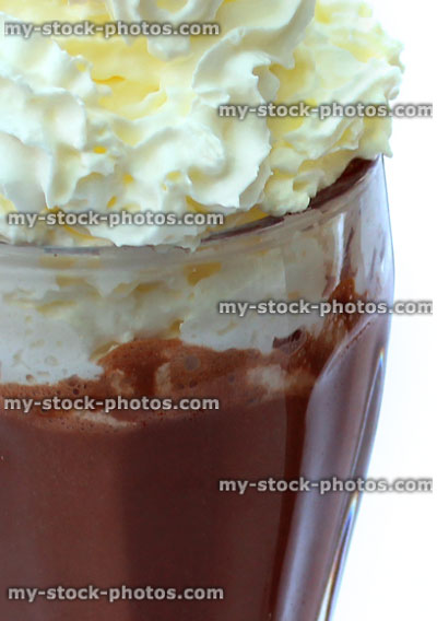 Stock image of chocolate milkshake topped with whipped cream, American diner glass