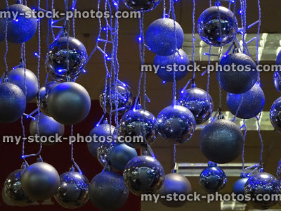 Stock image of hanging baubles, blue fairy lights and Christmas decorations