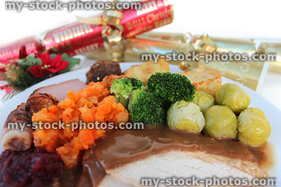 Stock image of Christmas dinner with crackers, roast turkey, sprouts, gravy