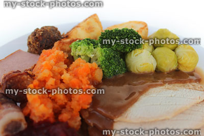Stock image of roast turkey Christmas dinner, winter vegetables, gravy, white plate