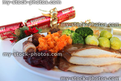 Stock image of Christmas dinner with roast turkey slices, vegetables, crackers