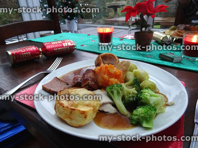 Stock image of Christmas dinner on dining table with candles, crackers