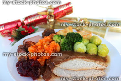 Stock image of Christmas dinner plate, roast turkey, winter vegetables, Xmas-crackers