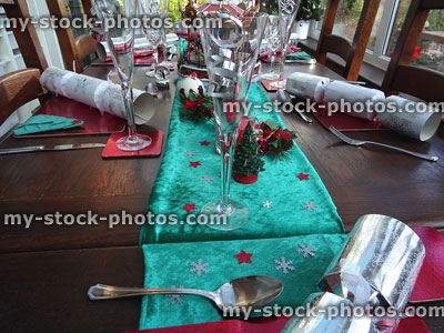 Stock image of Christmas table runner with decorations, Xmas-crackers, stars, wine-glasses