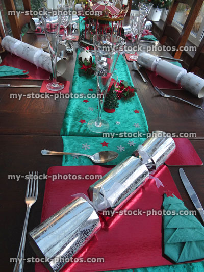 Stock image of Christmas dinner table, runner, crackers, cutlery, wine glasses