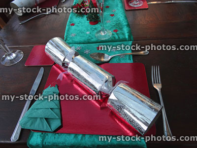 Stock image of Christmas dinner table place setting, tablemat, cutlery, crackers