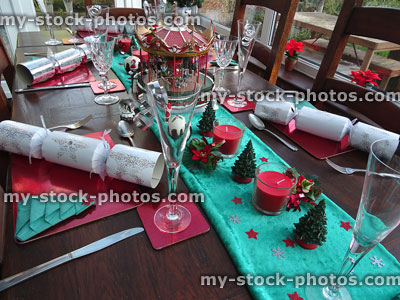 Stock image of decorated dining table at Christmas time, place-settings, crackers