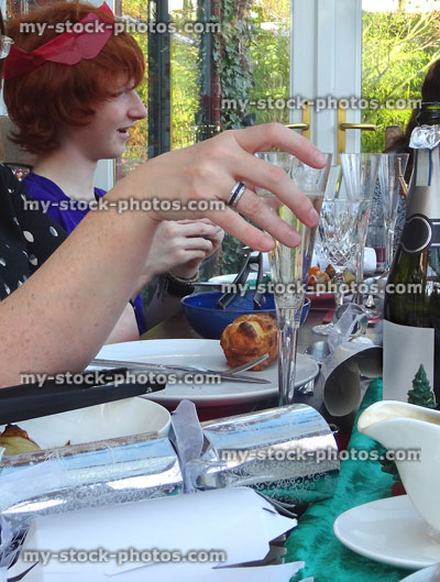 Stock image of family enjoying Christmas dinner, drinking wine glass, crackers