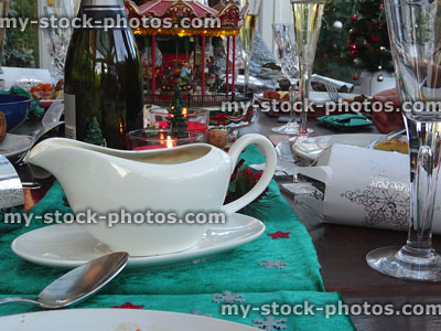 Stock image of white porcelain gravy boat with Christmas-dinner table decorations