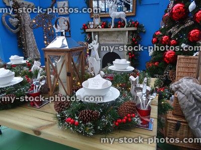 Stock image of Christmas table place settings, lantern, Xmas-tree and fireplace