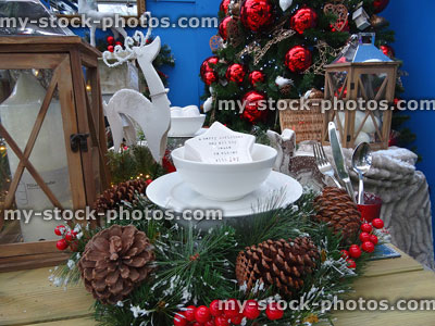 Stock image of crockery on Christmas dinner table place settings, wreath