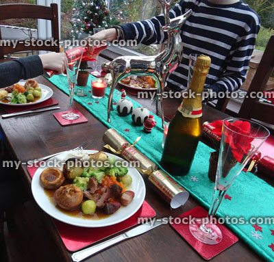 Stock image of children pulling Christmas crackers, roast dinners with table runner