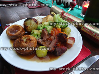 Stock image of a roast dinner with Christmas crackers, candles, cutlery