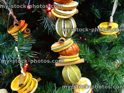 Stock image of Christmas tree decorations, fairy lights, dried fruit garland, cinnamon sticks