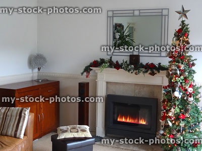 Stock image of sitting room with gas fireplace, garland, Christmas tree decorations