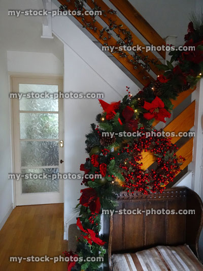 Stock image of hallway stairs decorated for Christmas, berry wreath, garland