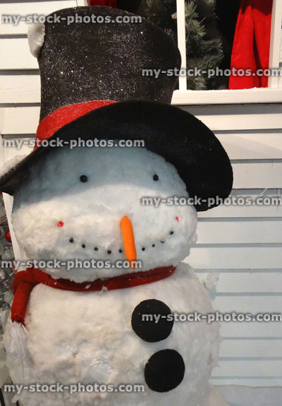 Stock image of large toy lifesize cartoon snowman outside house front door, winter Christmas display