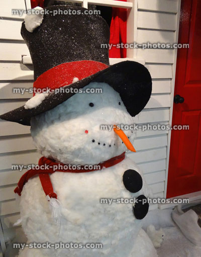 Stock image of large toy lifesize cartoon snowman outside house front door, winter Christmas display