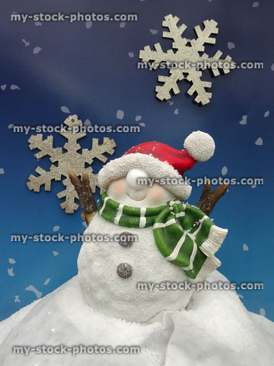 Stock image of Christmas snowman garden ornament with bobble hat, snowflake background